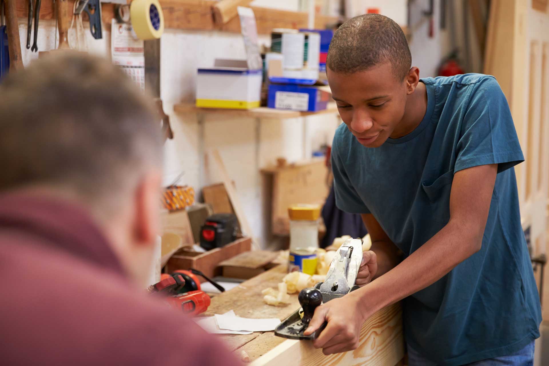 A teenage boy learns carpentry