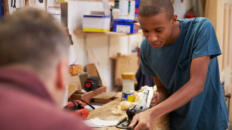 A teenage boy learns carpentry