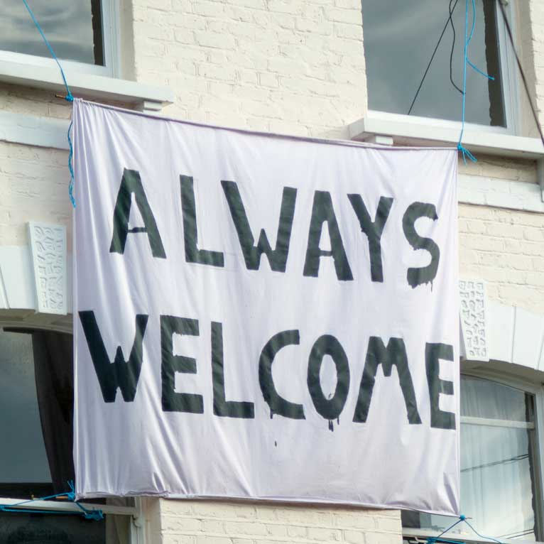 A sign hung from a window reads "Always welcome"