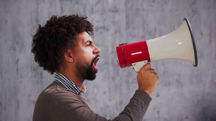 A man of colour shouts into a megaphone