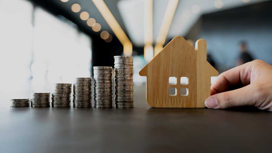 Increasingly large piles of coins next to a wooden house