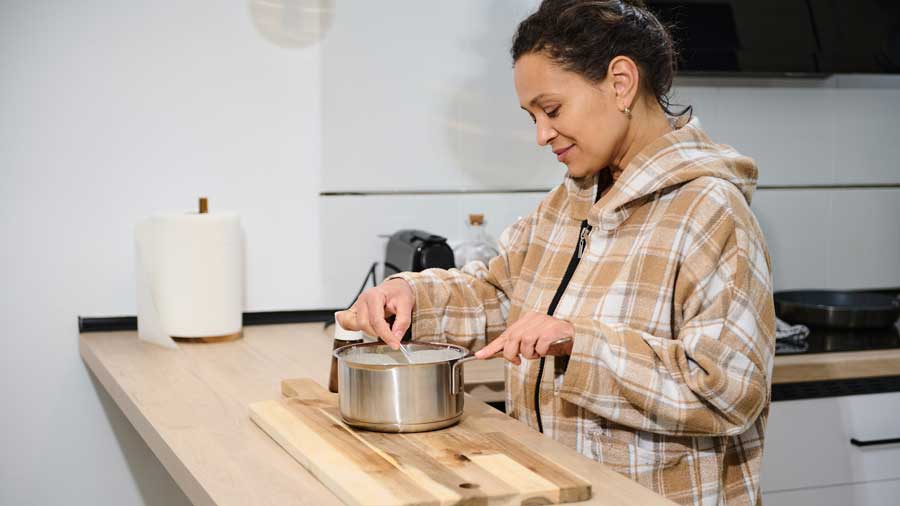A woman cooks in a basic kitchen