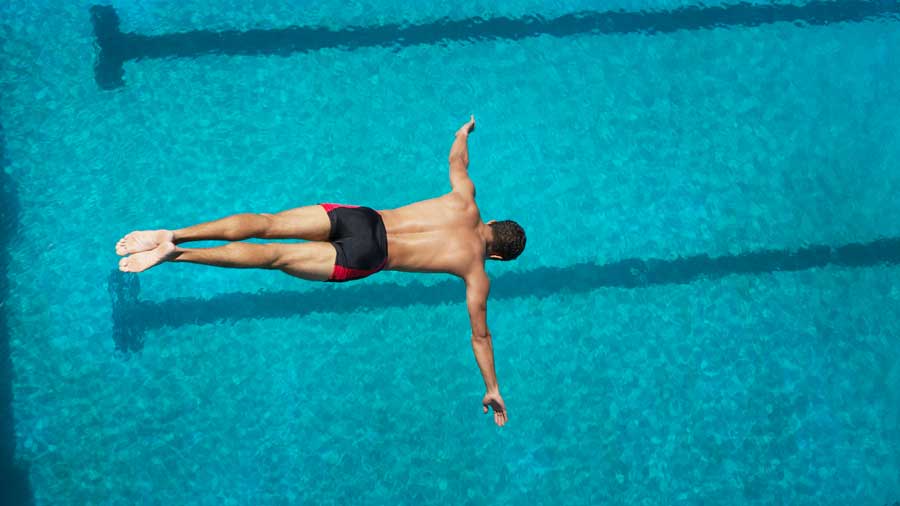 A man dives off a high platform into a pool