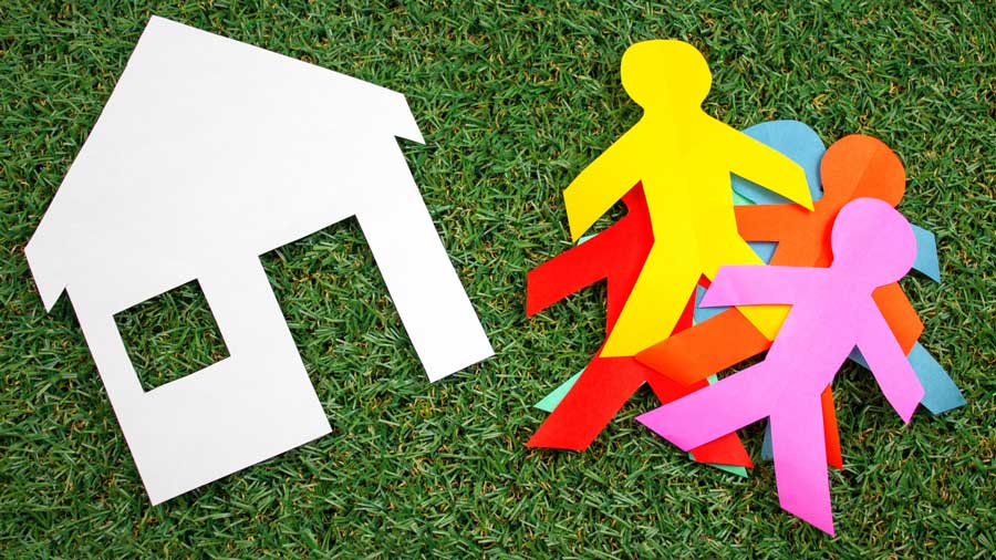A paper house with lots of paper cutouts of people - housing scarcity concept