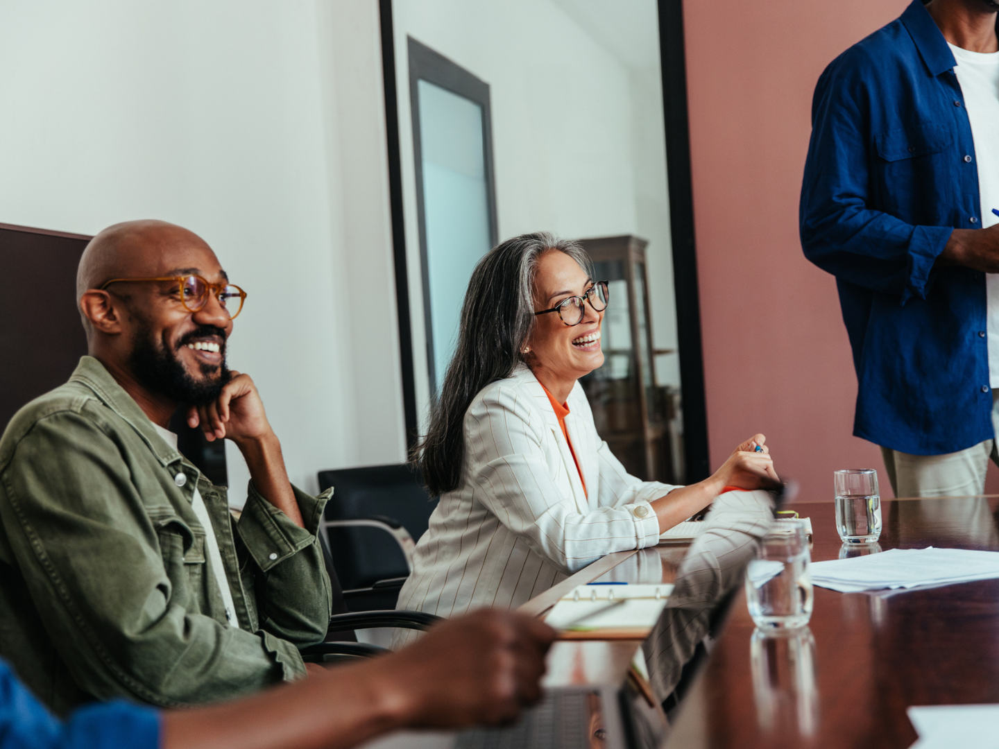 Happy colleagues laughing in a modern boardroom during a casual office meeting stock photo